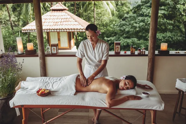 Therapist giving a traditional Balinese massage on a villa terrace in Bali